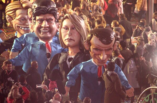 Артисты в костюмах, изображающих кандидатов на пост президента Франции Жан-Люк Меланшона, Марин Ле Пен и Эммануэля Макрона во время карнавала в Ницце