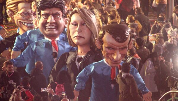 Артисты в костюмах, изображающих кандидатов на пост президента Франции Жан-Люк Меланшона, Марин Ле Пен и Эммануэля Макрона во время карнавала в Ницце. Архивное фото