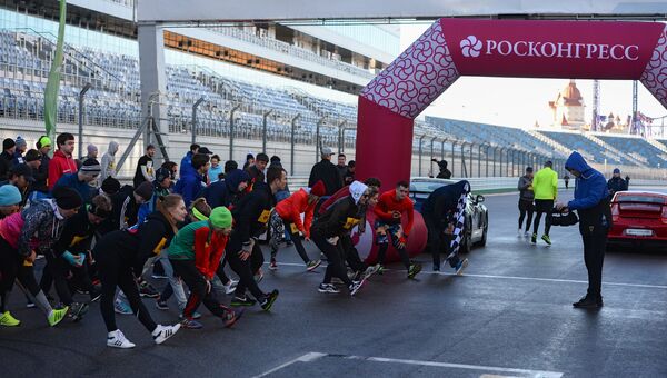 Участники легкоатлетического забега по трассе Гран-при России Формулы-1 в Сочи разминаются перед стартом