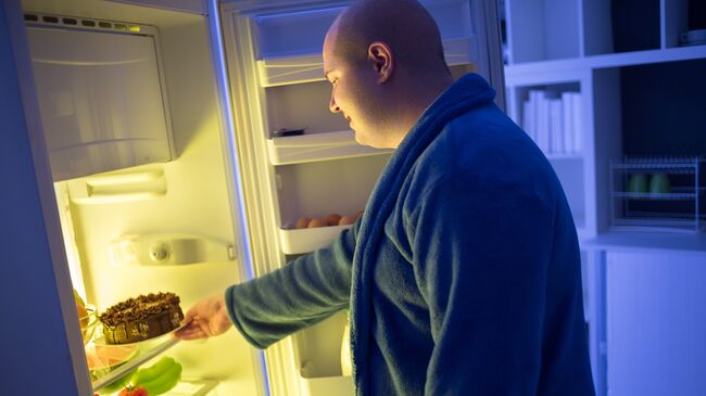 Толстый мужчина у холодильника. Архивное фото