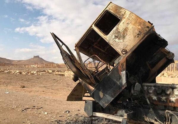 Кабина сгоревшего грузовика неподалеку от историко-архитектурного комплекса Древней Пальмиры в сирийской провинции Хомс
