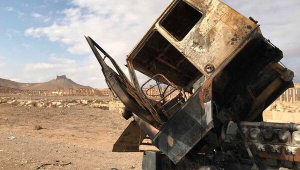 Кабина сгоревшего грузовика неподалеку от историко-архитектурного комплекса Древней Пальмиры в сирийской провинции Хомс