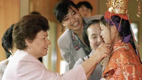 Супруга Президента РФ Наина Ельцина рассматривает наряд юной жительницы Токио на демонстрации коллекции кимоно и искусства икебаны во время визита в Японию