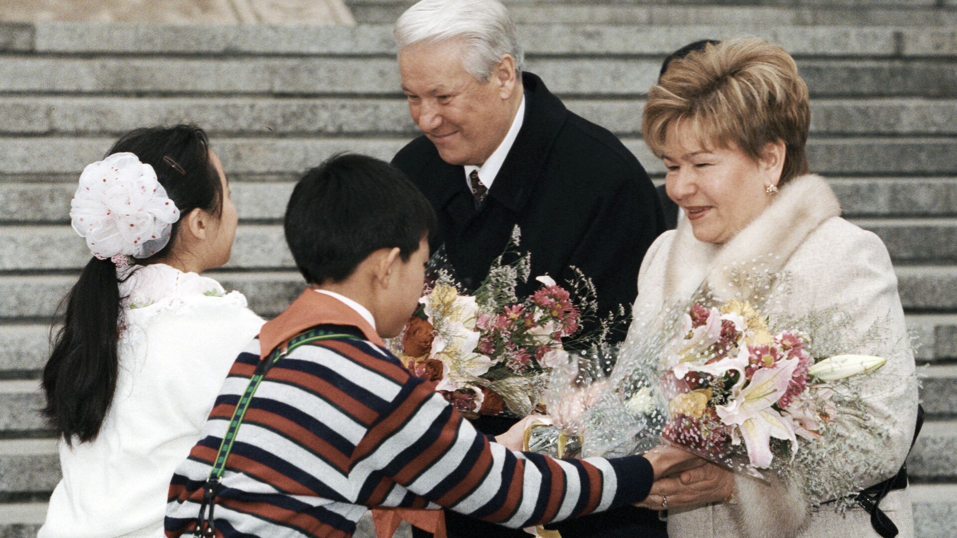 Юные жители Пекина приветствуют Президента РФ Бориса Ельцина и его супругу Наину Ельцину во время визита в КНР Юные жители Пекина приветствуют Президента РФ Бориса Ельцина и его супругу Наину Ельцину во время визита в КНР - РИА Новости, 1920, 12.07.2025