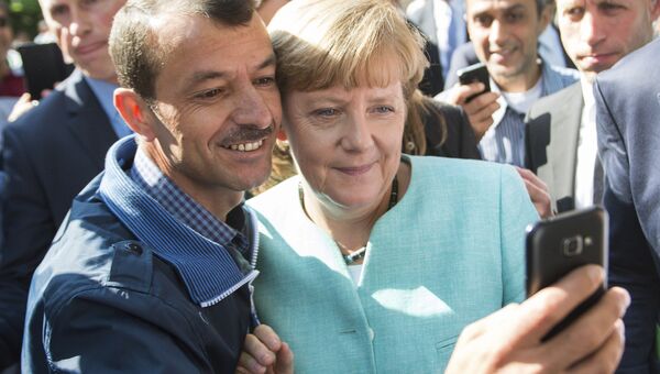 Беженец делает селфи с канцлером Германии Ангелой Меркель. Архивное фото