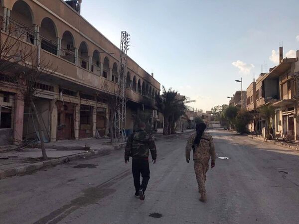 Солдаты у разрушенных в результате боевых действий домов в жилой части города Пальмира в сирийской провинции Хомс