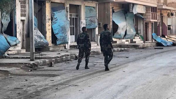 Солдаты у разрушенных в результате боевых действий домов в жилой части города Пальмира в сирийской провинции Хомс