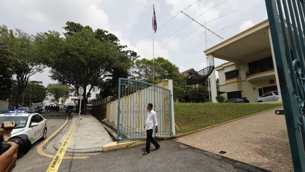 Сотрудник посольства КНДР выходит из оцепленного полицией здания посольства в Куала-Лумпуре. Архивное фото