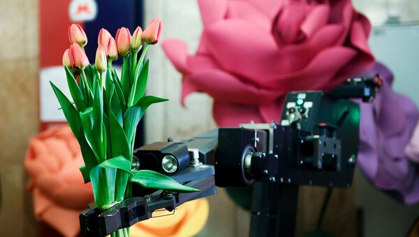 Тюльпаны в руке робота ЦСООР Лидер на станции московского метро. 7 марта 2017