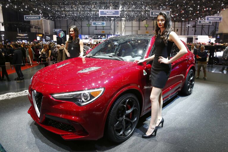 Модели позируют возле автомобиля Alfa Romeo Stelvio на Женевском международном автосалоне