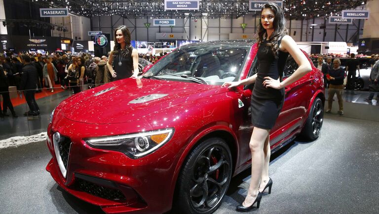 Модели позируют возле автомобиля Alfa Romeo Stelvio на Женевском международном автосалоне