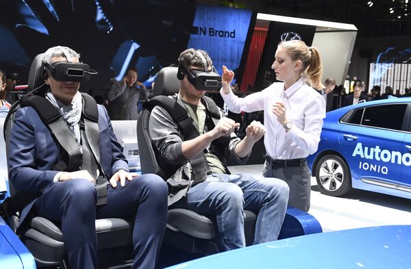 Посетители в очках виртуальной реальности на Женевском международном автосалоне