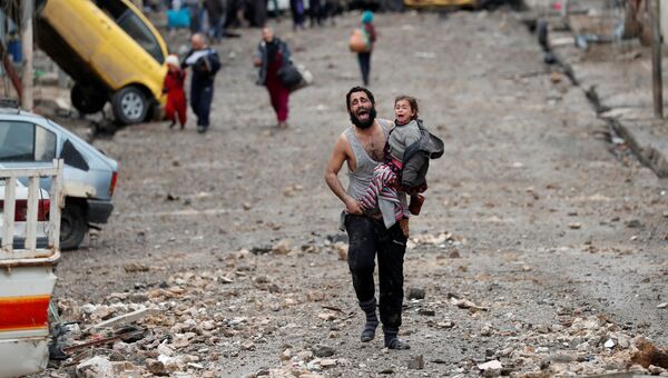 Отец с дочерью бегут с подконтрольных боевикам Исламского государства (ИГ, запрещена в РФ) территорий во время битвы за Мосул