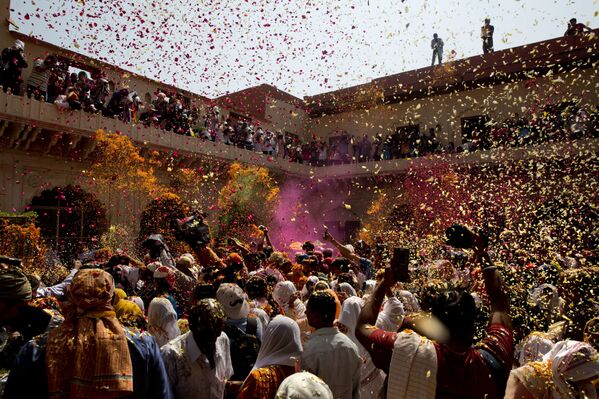 Местные жители и овдовевшие женщины принимают участие в фестивале Холи в храме Гопинатхи во Вриндаване, Индия