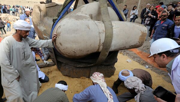 Египетские рабочие возле статуи древнеегипетского фараона Рамзеса Второго, обнаруженой археологами в районе Матария в Каире