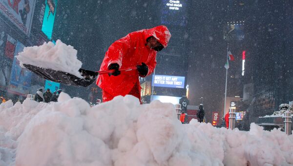 Работник чистит снег на Таймс-сквер в Манхэттене, Нью-Йорк, США. 14 марта 2017
