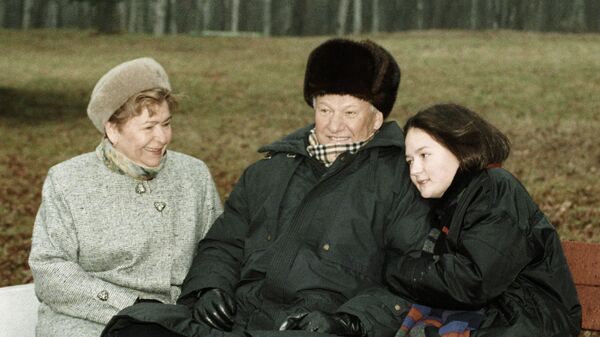 Президент РФ Борис Ельцин сидит на скамье во время прогулки с супругой Наиной и внучкой Машей 
