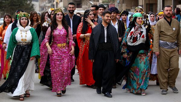 Мужчины и женщины в традиционной курдской одежде в городе Эль-Камышлы, Сирия