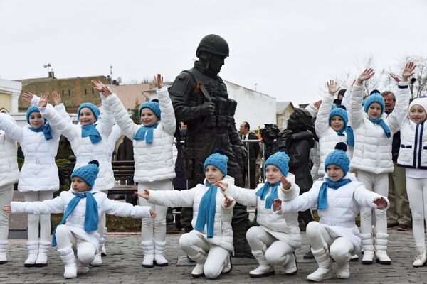 Участники у памятника Вежливым людям во время праздничных мероприятий, посвященных Дню Общекрымского референдума 2014 года, в Симферополе.