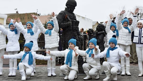 Участники у памятника Вежливым людям во время праздничных мероприятий, посвященных Дню Общекрымского референдума 2014 года, в Симферополе.