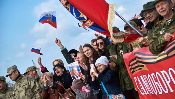 Участники митинга в честь третьей годовщины воссоединения Крыма с Россией на мысе Хрустальный в Севастополе