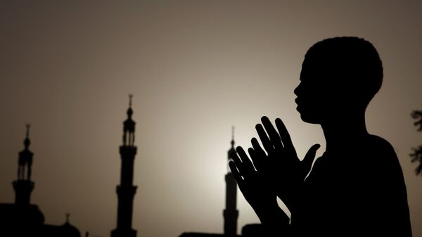 Суданский мальчик молится у мечети в Хартуме
