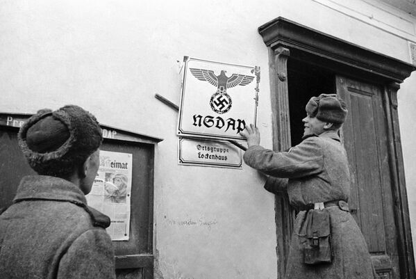 Советские бойцы - освободители Австрии от фашизма в селении Лекенгауз срывают вывески с фашистских учреждений