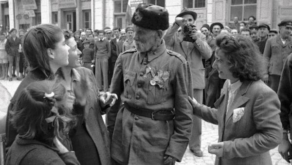 Ветеран турецкой войны беседует с девушками, в освобожденном войсками РККА от фашистов, болгарском городе