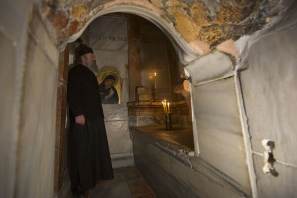Греческий священник внутри отреставрированной Кувуклии в храме Гроба Господня в Иерусалиме