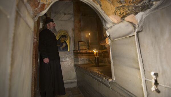 Греческий священник внутри отреставрированной Кувуклии в храме Гроба Господня в Иерусалиме
