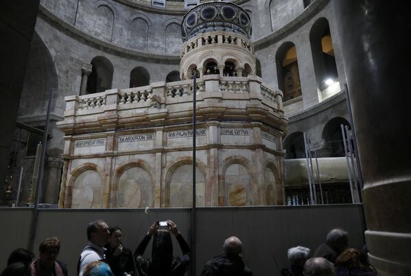 Посетитель фотографирует отреставрированную Кувуклию в храме Гроба Господня в Иерусалиме