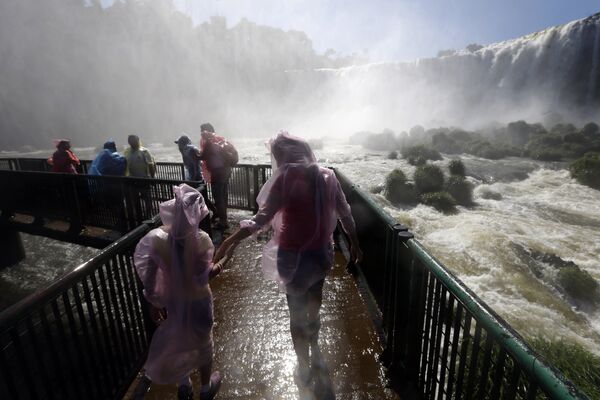 Туристы посещают водопад Игуасу в Бразилии