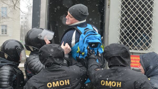 Сотрудники ОМОНа задерживают мужчину во время несанкционированной акции оппозиции в Минске.