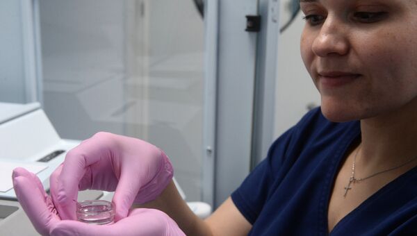 Медик демонстрирует чашку Петри с питательной средой для эмбрионов. Архивное фото