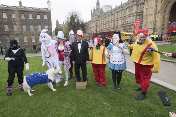 Люди в костюмах персонажей Алисы в стране Чудес Л. Кэролла проводят у здания Парламента в Лондоне акцию протеста против выхода Великобритании из ЕС