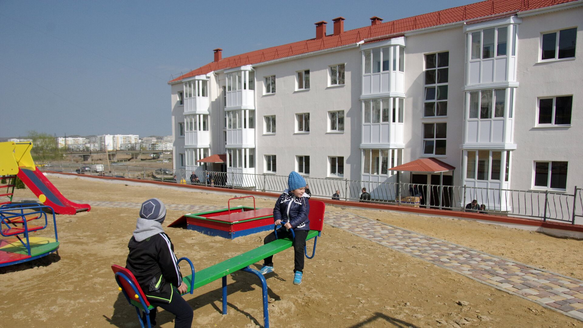 Дети играют на детской площадке у новых домов в Крыму, построенных для переселенцев из зоны строительства Керченского моста - РИА Новости, 1920, 10.02.2020