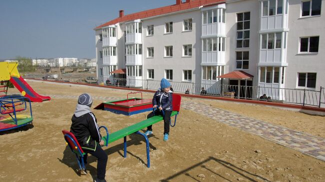 Дети играют на детской площадке у новых домов в Крыму, построенных для переселенцев из зоны строительства Керченского моста