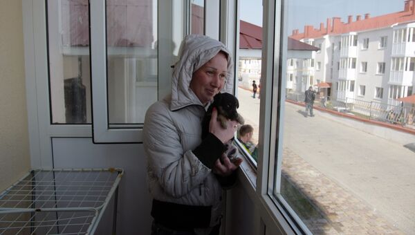 Женщина на балконе в новой квартире в Крыму, переехавшей из зоны строительства Керченского моста