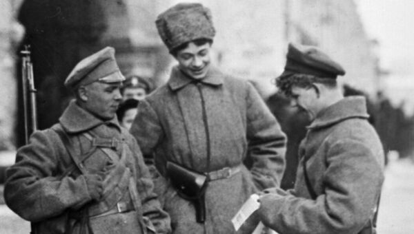Вооруженные красногвардейцы читают листовку на улице Петрограда