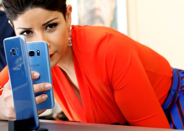 Девушка фотографирует смартфон Samsung Galaxy S8 + с Galaxy S7 на презентации в Нью-Йорке