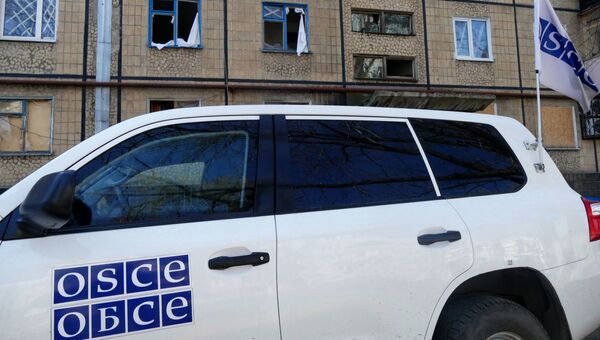 Автомобиль представителей ОБСЕ у жилого дома, Автомобиль представителей ОБСЕ у жилого дома, поврежденного в результате обстрелов, в Киевском районе Донецка. Архивное фотов результате обстрелов, в Киевском районе Донецка