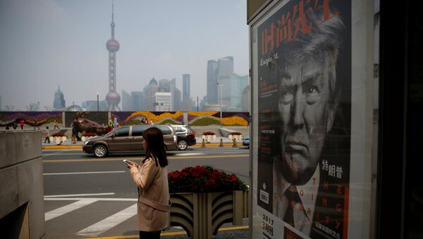 Стенд с изображением президента США Дональда Трампа на улице в Шанхае. 21 марта 2017 года