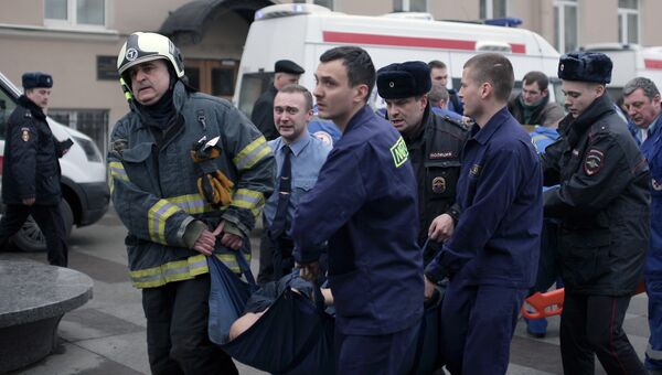 Сотрудники спецслужб несут пострадавшего у станции метро Технологический институт в Санкт-Петербурге