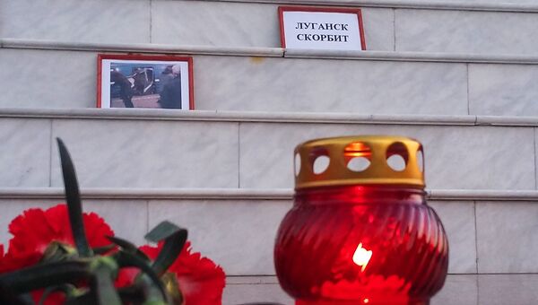 Цветы и свечи в память о погибших во время взрыва у станции Сенная площадь в Луганске