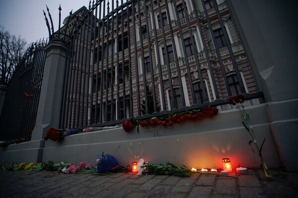 Цветы и свечи у посольства РФ в Риге в память о погибших в результате взрыва в метро Санкт-Петербурга