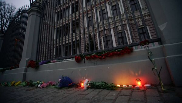 Цветы и свечи у посольства РФ в Риге в память о погибших в результате взрыва в метро Санкт-Петербурга