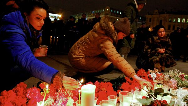 Горожане зажигают свечи у входа в вестибюль станции метро Спасская в память о погибших в результате взрыва в метро Санкт-Петербурга