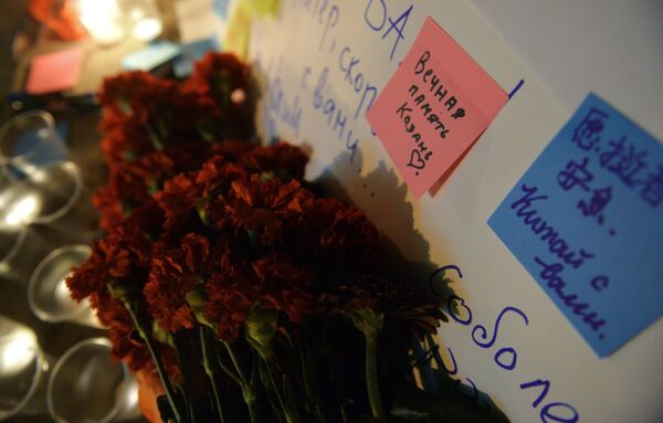 Люди приносят цветы и свечи к вестибюлю станции метро Площадь Тукая в Казани в память о жертвах теракта в метро Санкт-Петербурга