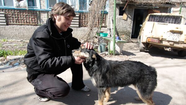 Местный житель с собакой на улице Привокзальной в прифронтовом поселке Донецк-Северный в Донецкой области