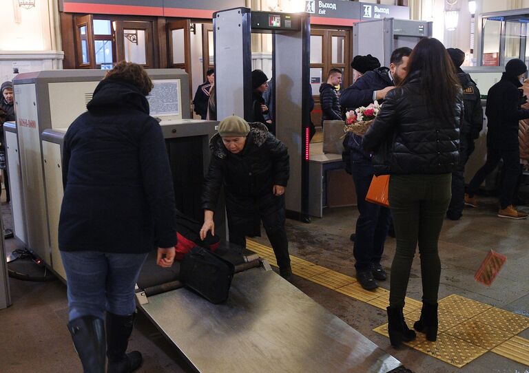 Сотрудники службы безопасности досматривают багаж пассажиров в здании Ленинградского вокзала в Москве Сотрудники службы безопасности досматривают багаж пассажиров в здании Ленинградского вокзала в Москве